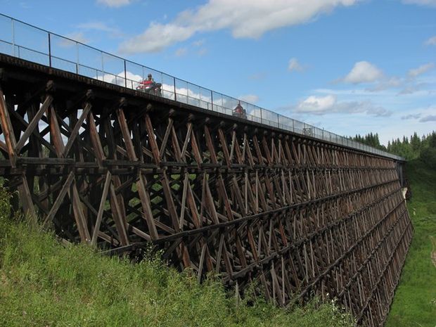 People crossing Beaver River Trestle on quads.