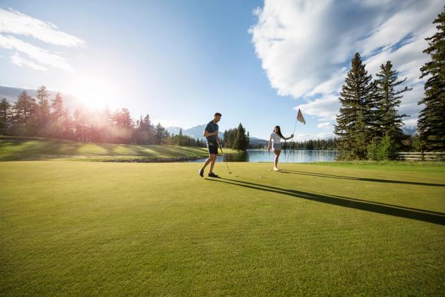 Couple golfing at the Fairmont Jasper Park Lodge Golf Course.