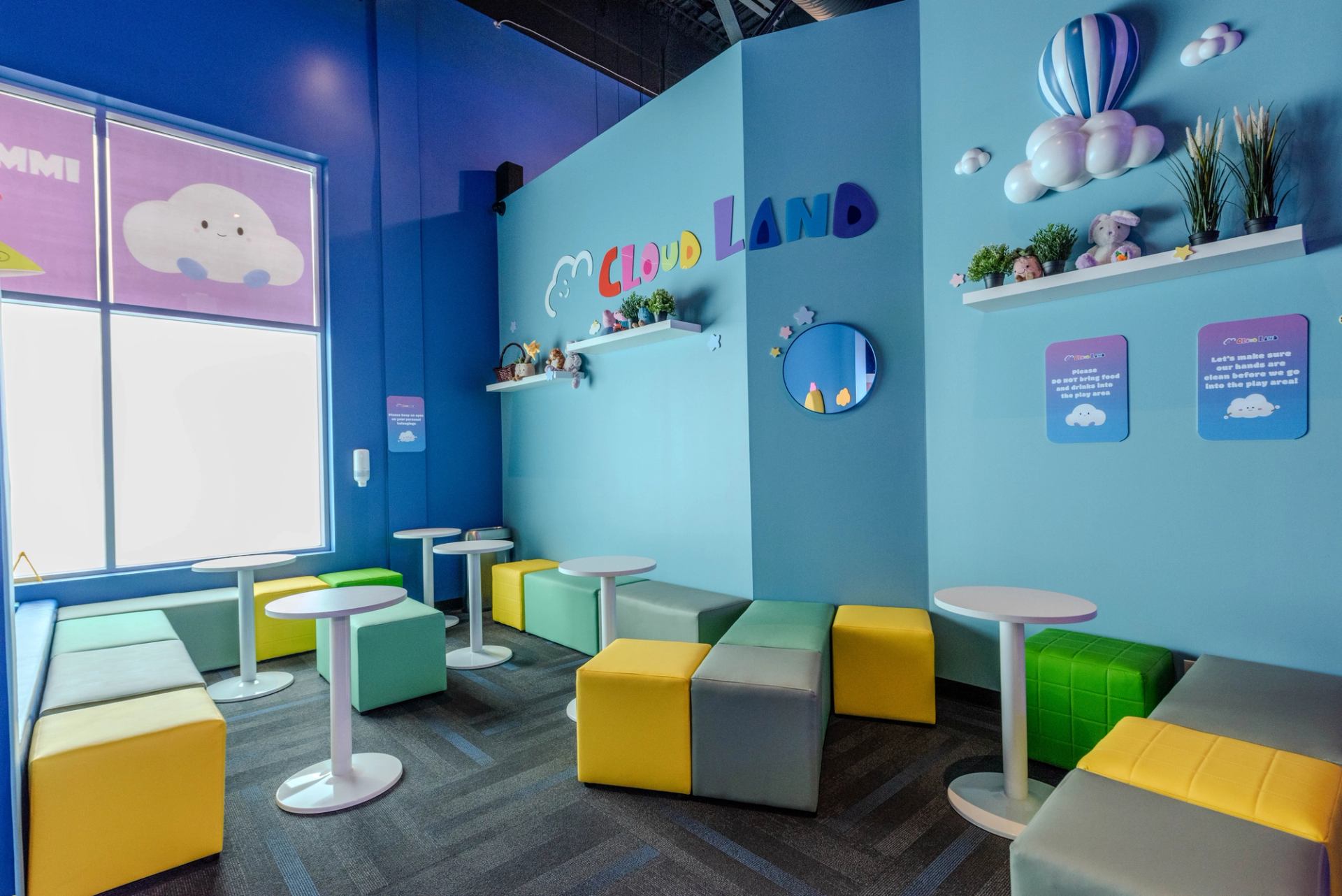 Colorful seating area at Cloud Land with playful decor and bright blue walls.