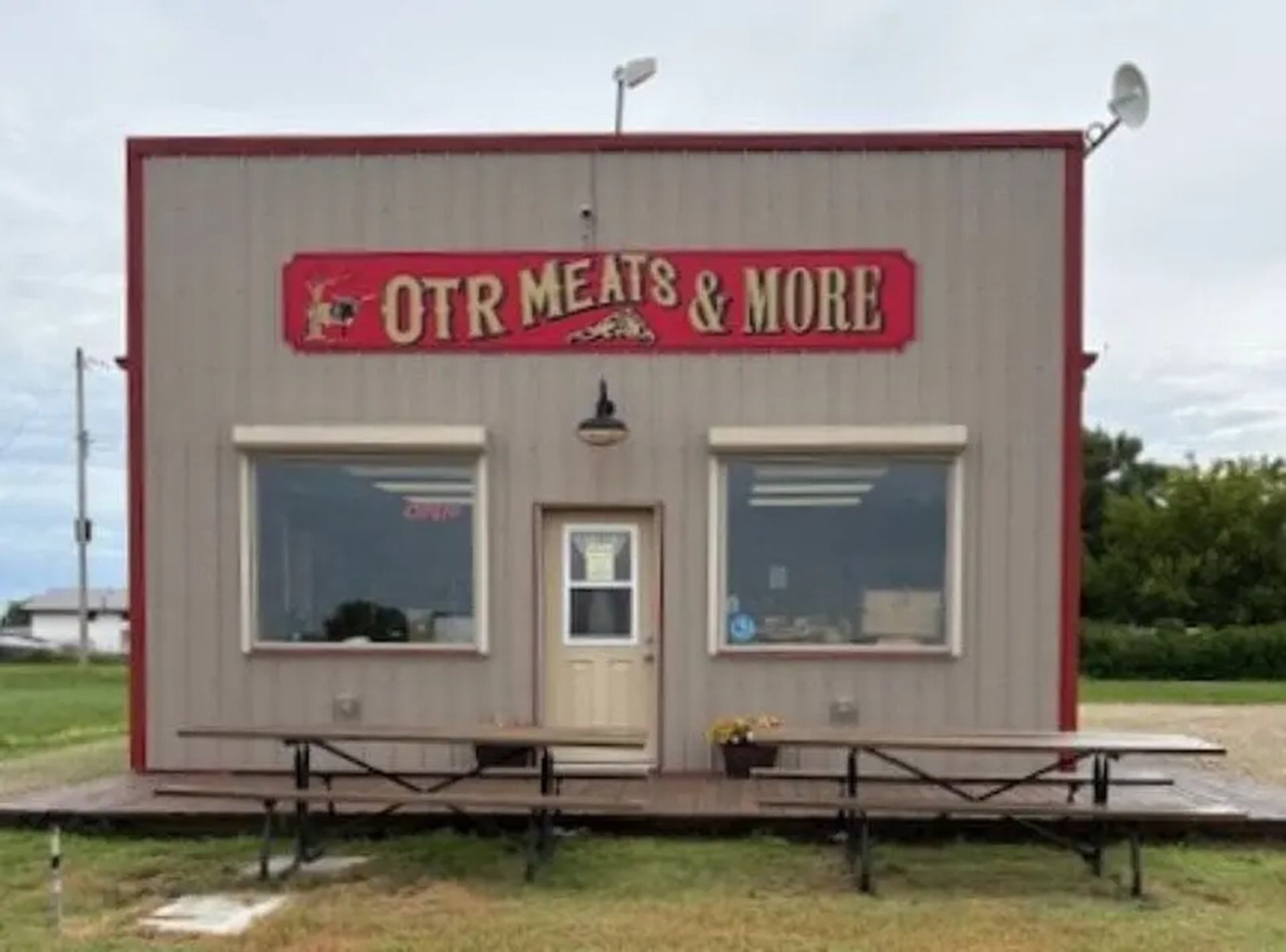 Small OTR Meats & More shop with front deck and picnic tables.