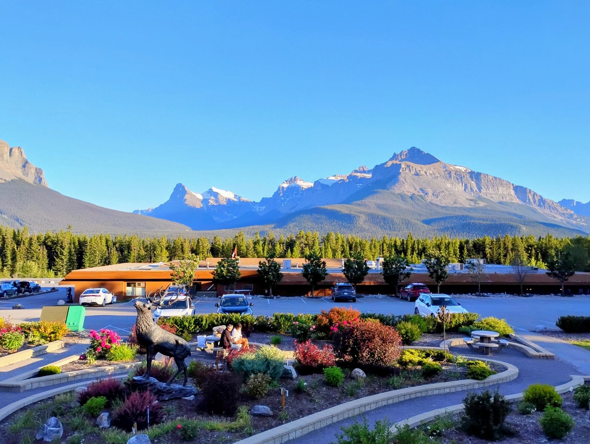 Mountain view overlooking The Crossing Resort with gardens and parked vehicles in front.