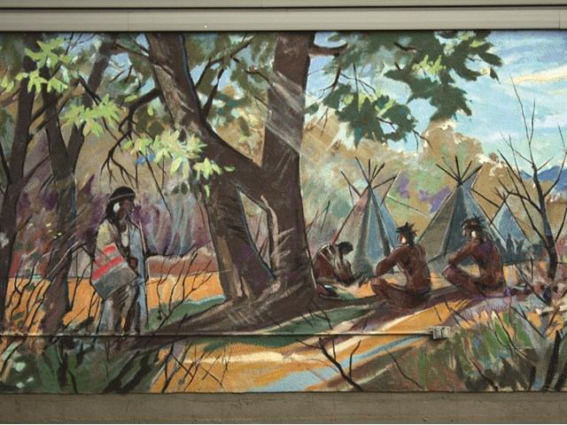 Mural of Indigenous life with teepees, campfire, and forest backdrop in High River.