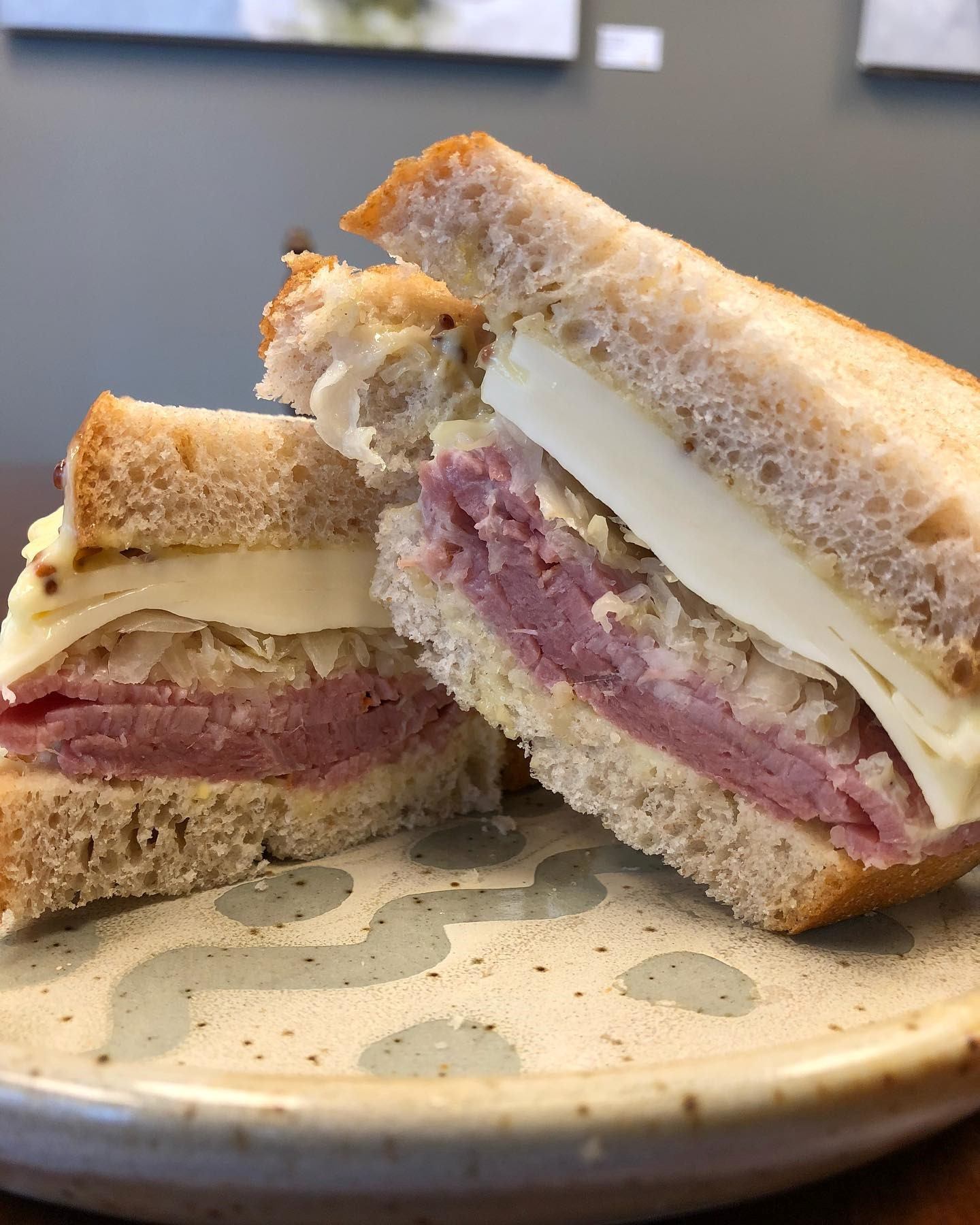 Sandwich with meat and cheese layers on a plate.