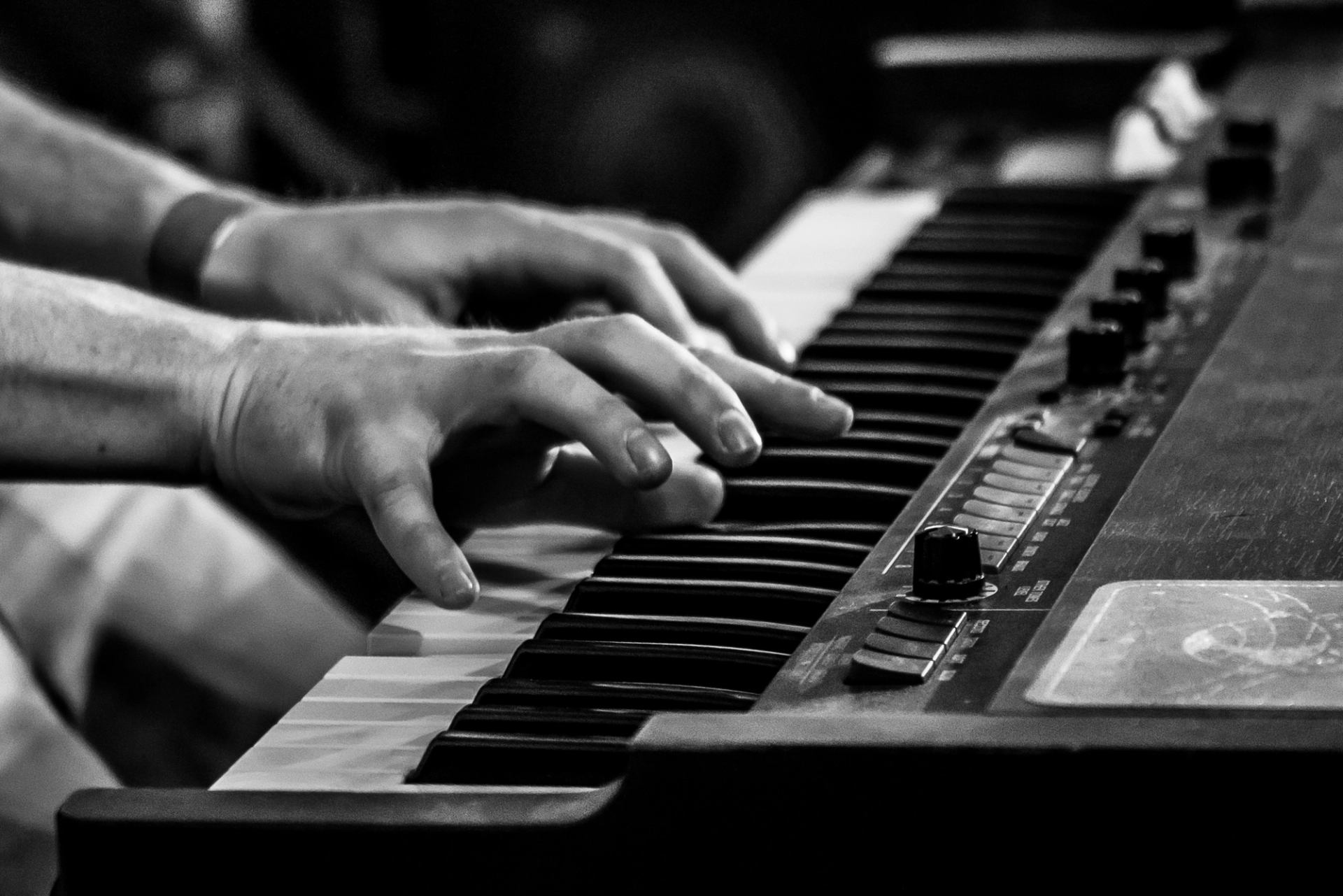 Close-up of hands playing a keyboard piano during a live performance at East Coulee SpringFest.