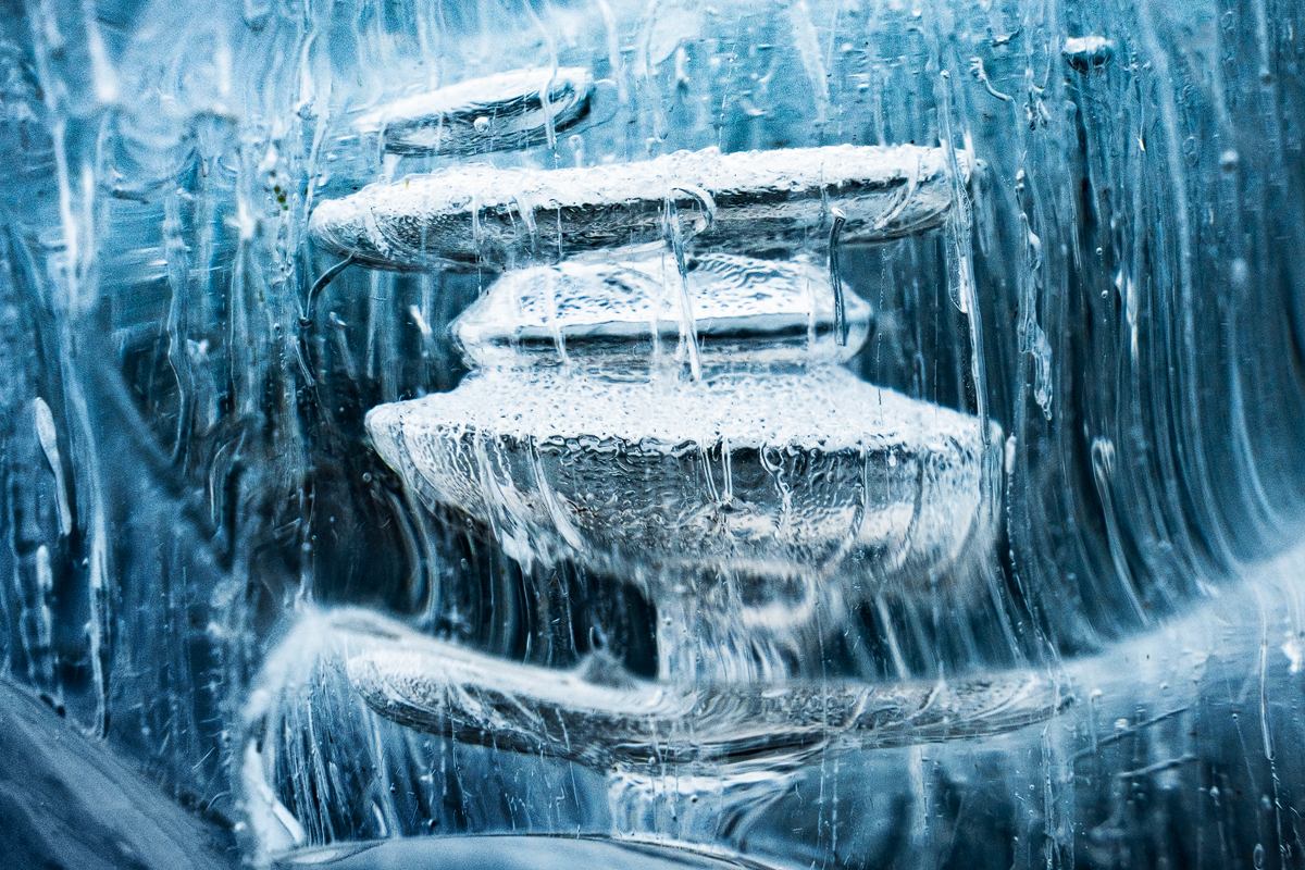 Close-up of frozen methane bubbles stacked inside clear blue ice on Abraham Lake.