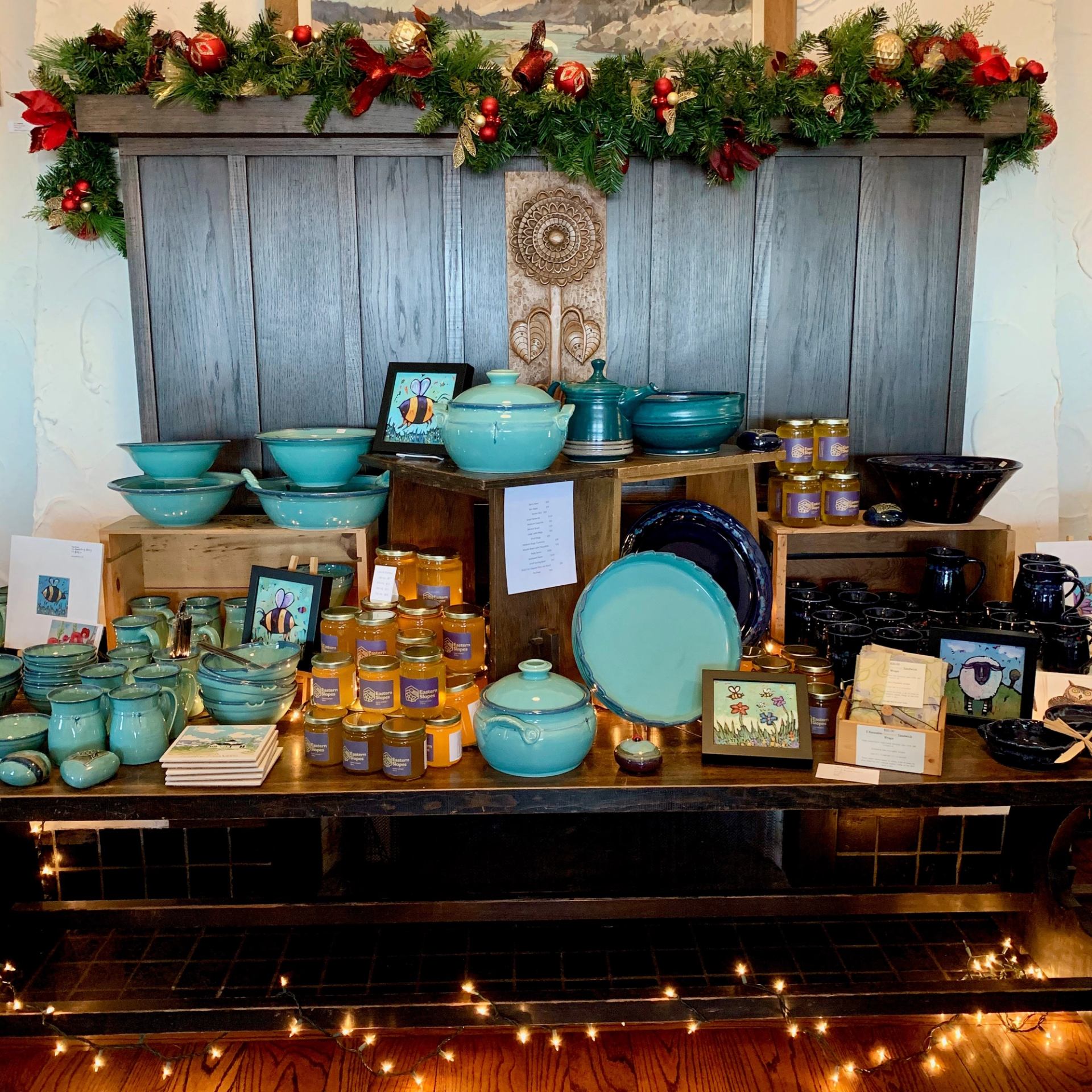 Turquoise ceramics and festive decor on display with jams and handmade gifts.