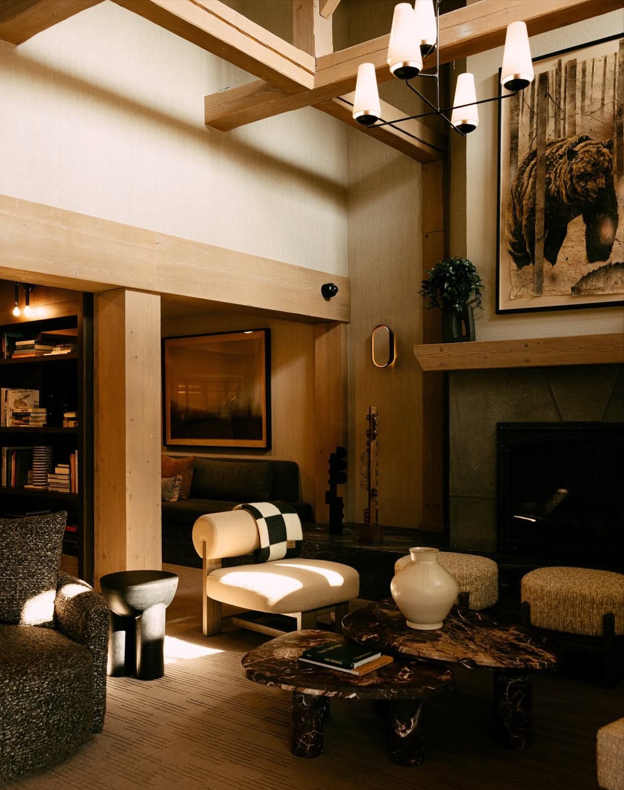 Stylish lounge with wood beams, modern furniture, and cozy fireplace.