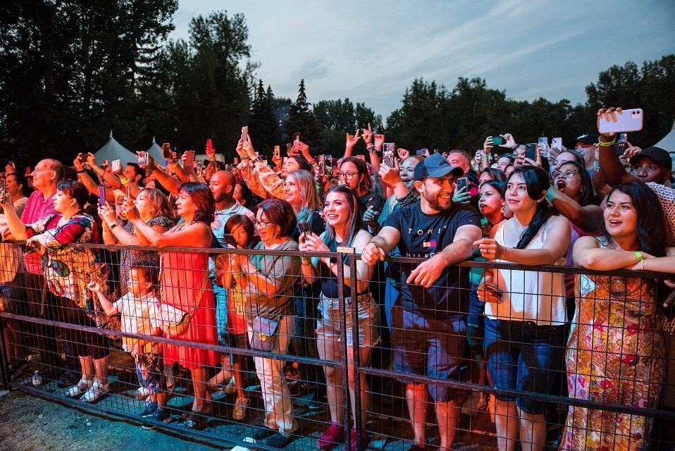 Expo Latino attendees behind barrier at outdoor concert.