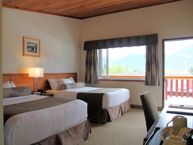 Cozy lodge room with mountain view and rustic wooden ceiling.