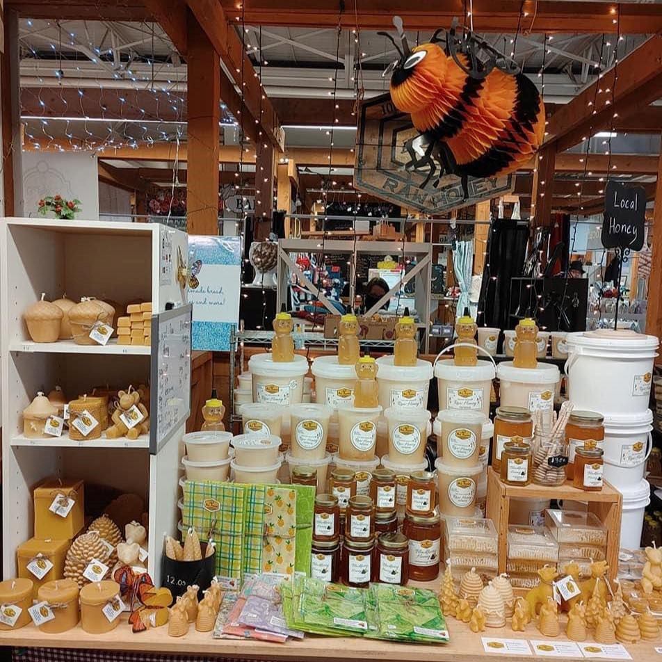 Honey and candles displayed at Grande Prairie Farmers' Market inside wooden market stalls.