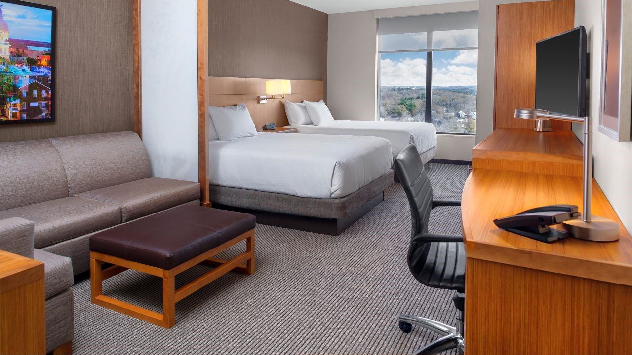 Hyatt Place room with two beds, sofa, desk, and large window view.