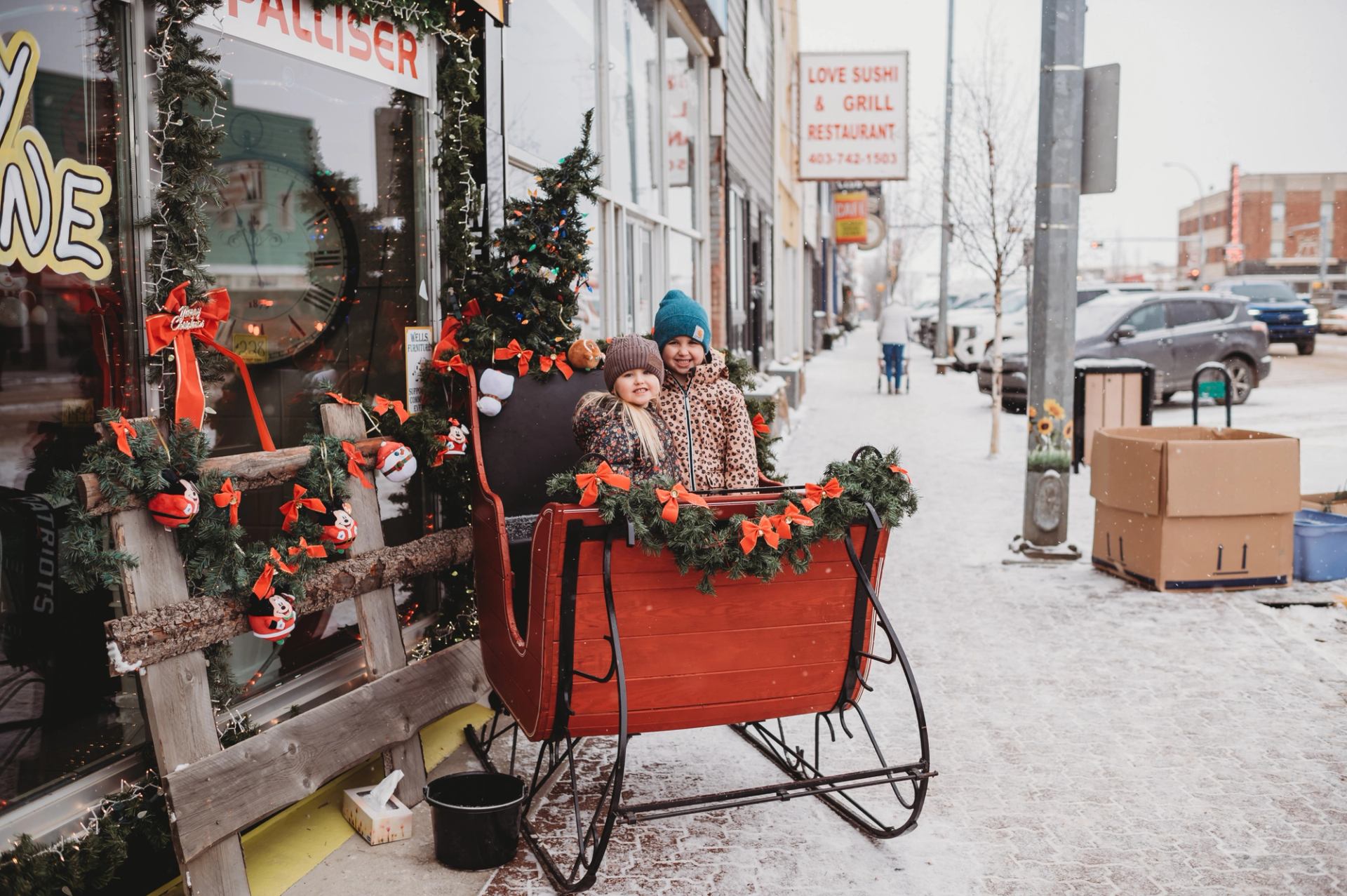 Little girls enjoy a sled photo opp set up by a local business.