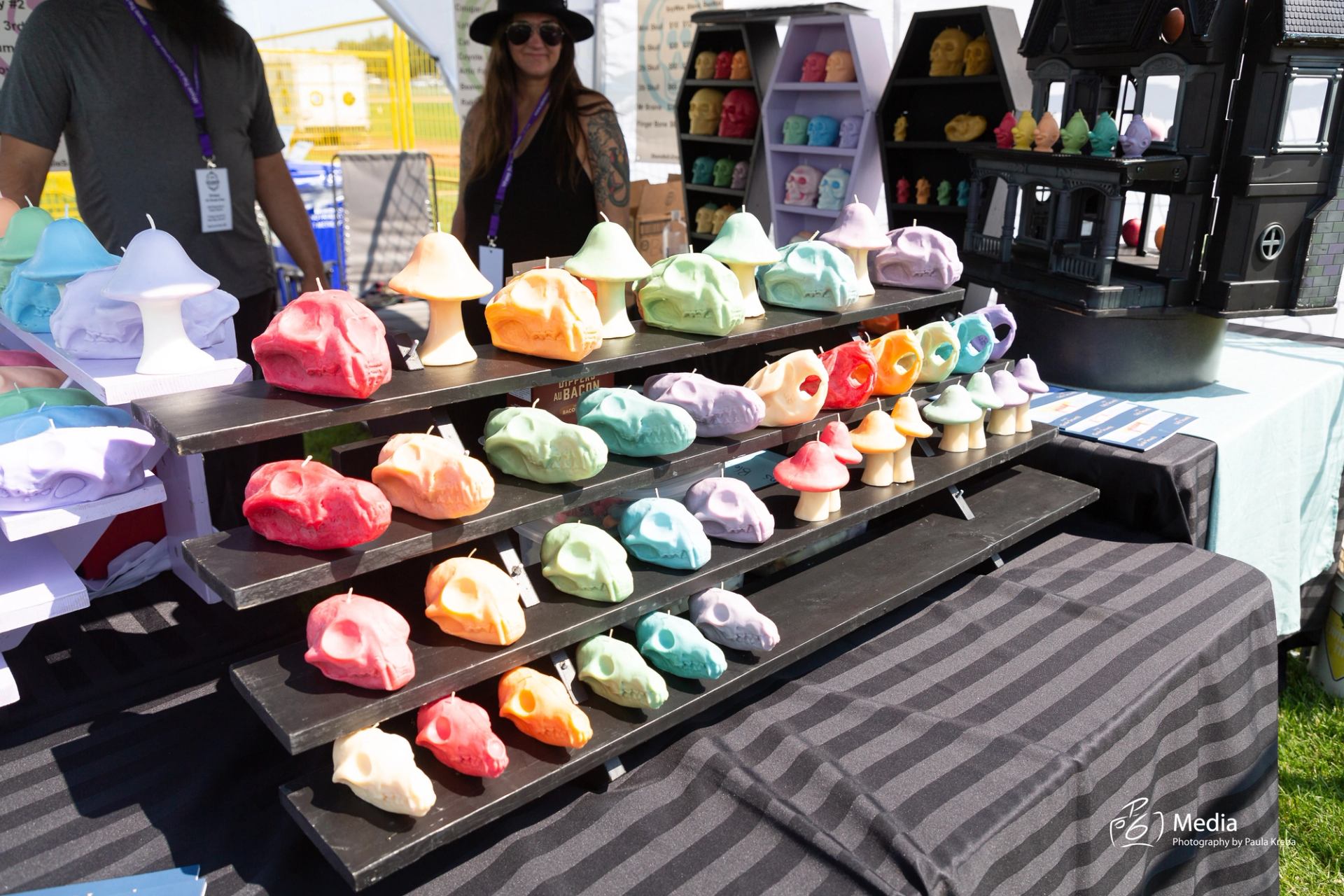 Colorful handmade soaps displayed on a tiered stand at an outdoor market booth.