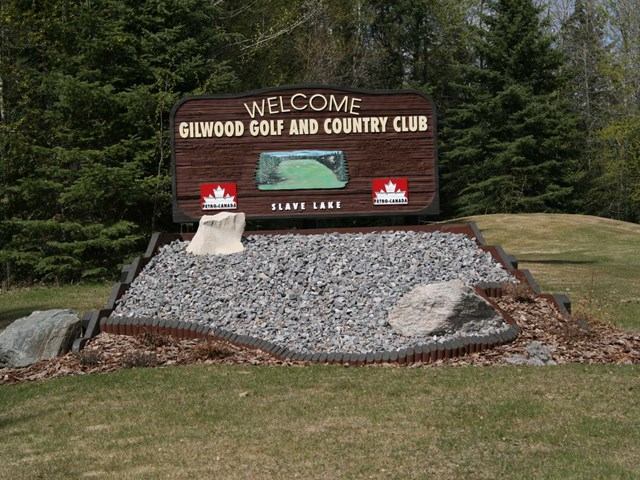 Welcome sign for Gilwood Golf and Country Club beside a landscaped entrance feature and grass.