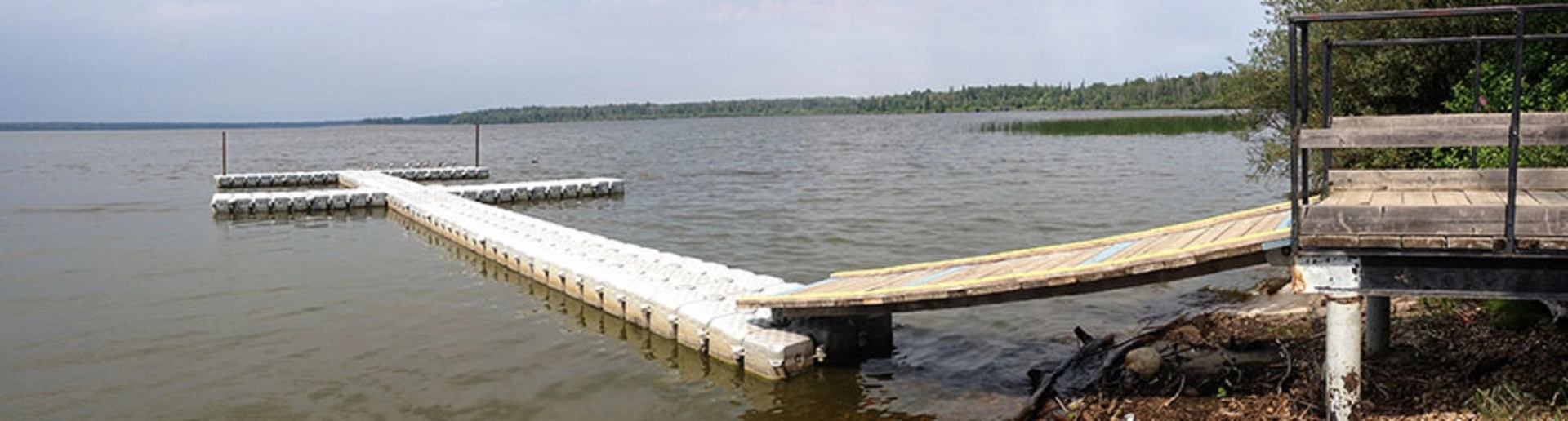 Floating dock extends into the still waters of Iosegun Lake near a wooden platform.