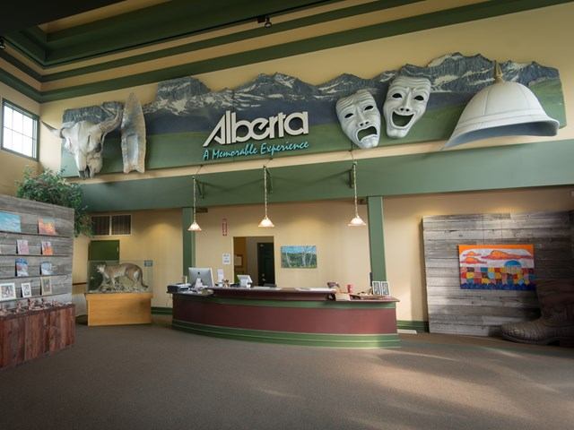 Interior of Cardston VIC with Alberta-themed sign and brochure counter.
