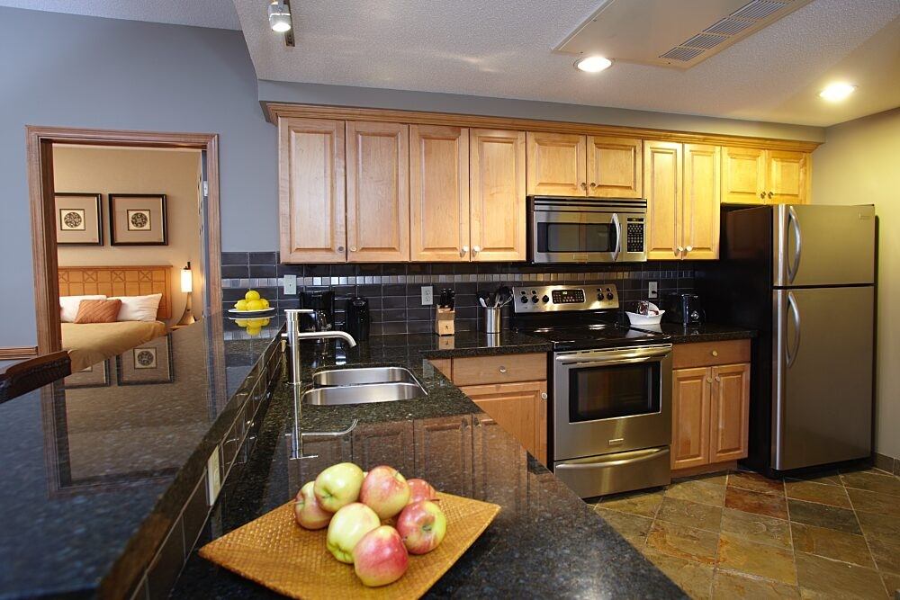Kitchen with stainless steel appliances, wooden cabinets, and counter