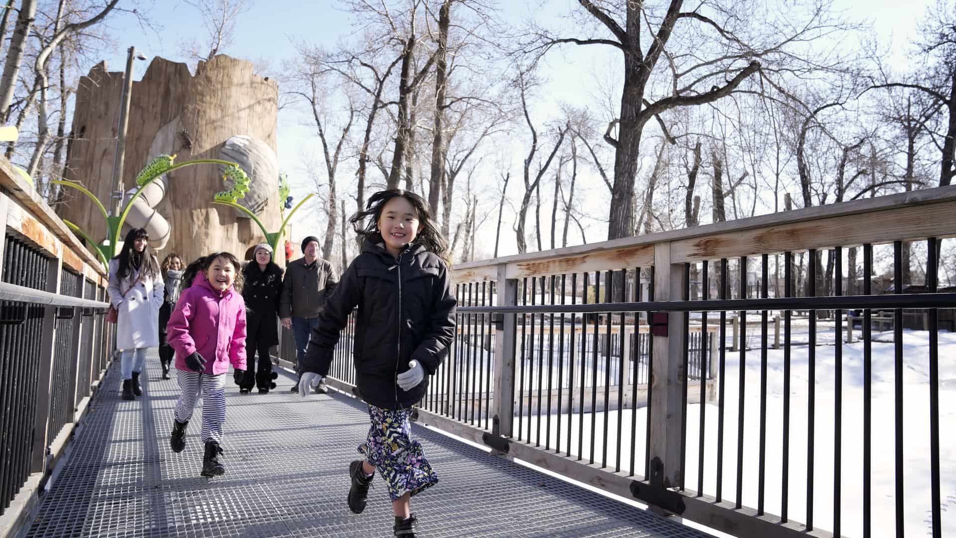 Kids and adults walking on a bridge.