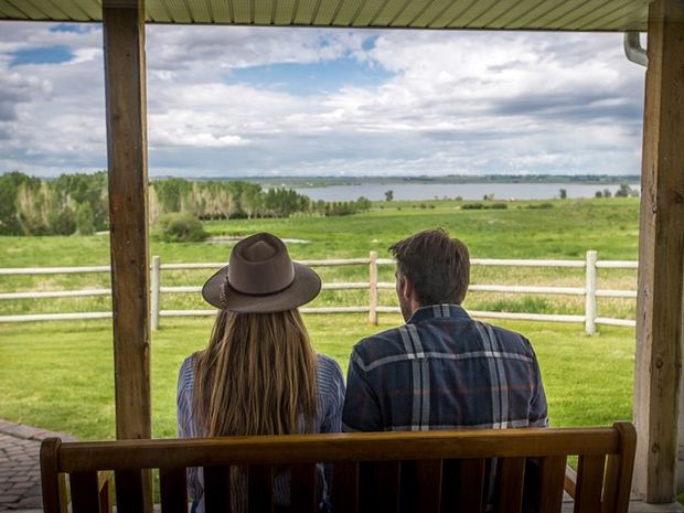 Two people sit on a porch.