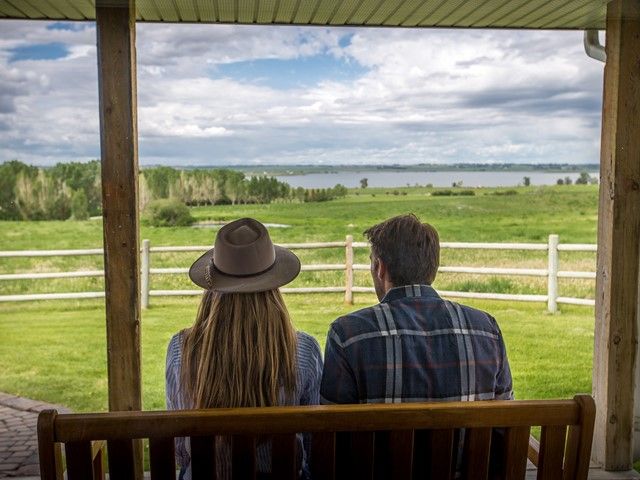 Two people sit on a porch.