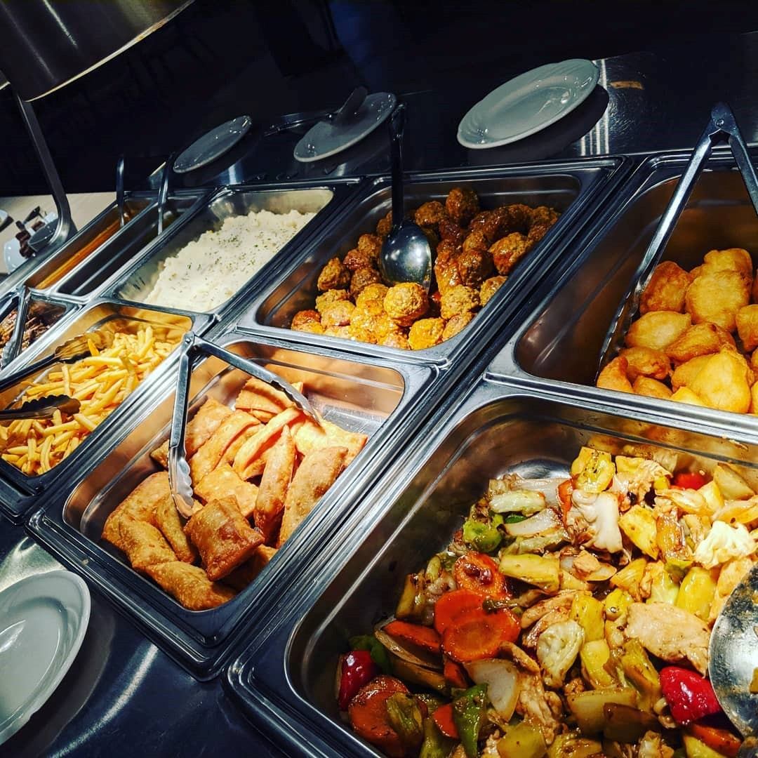 Buffet at JB Grill & Bar with fried chicken, rice, veggies, and sides.
