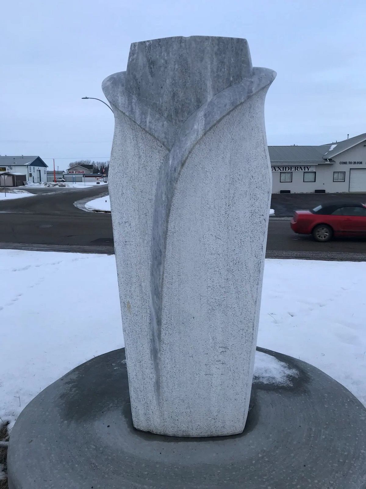 Stone sculpture represents a flower and a womans torso.