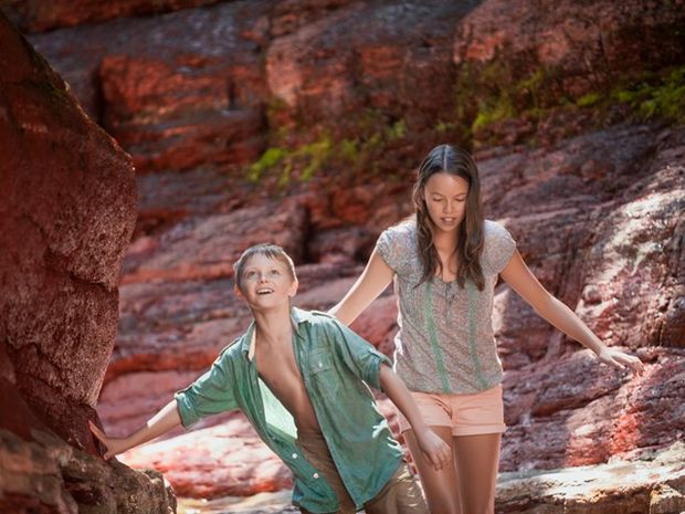 Two young kids exploring Red Rock Canyon at Waterton Lakes National Park.