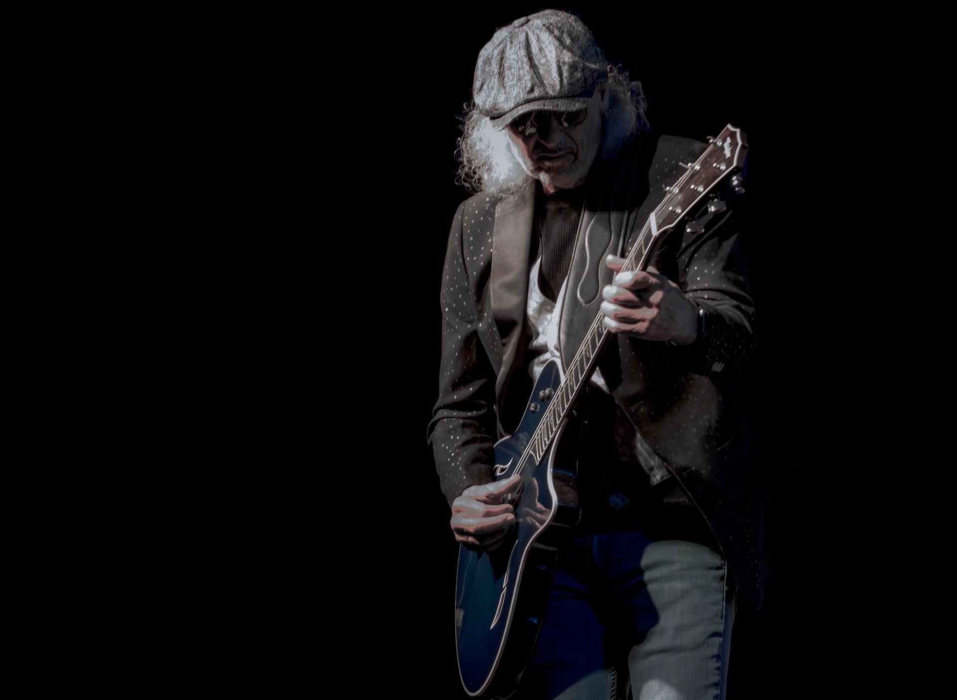 Michael Charles playing electric guitar on stage.