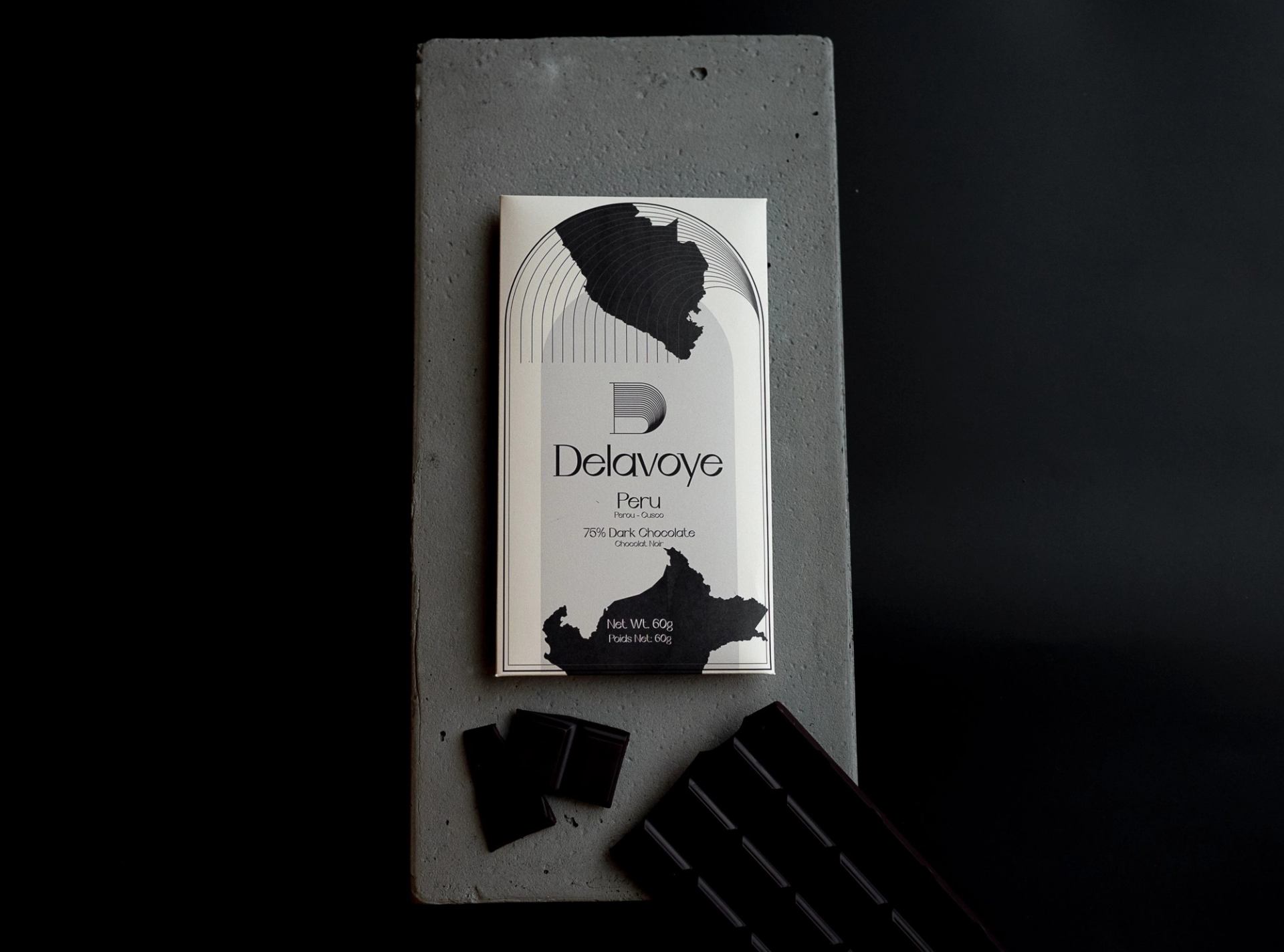 Delavoye chocolate bar package on concrete wall with Peru label and dark chocolate text.