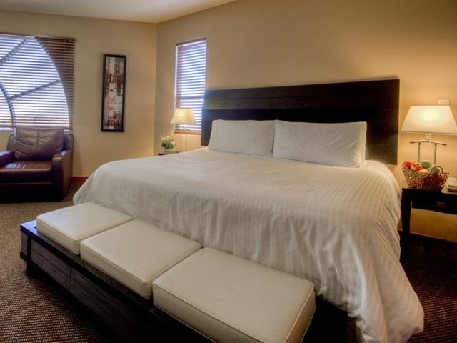 Elegant hotel room with plush bed, benches, and cozy lighting at Podollan Inn and Spa.
