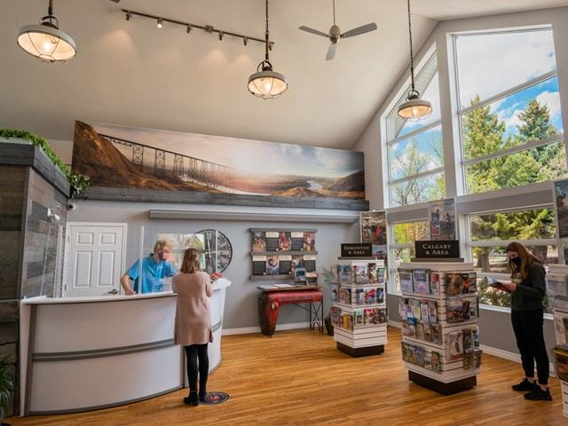 Visitor talking to Guide as another women looks at brochures.