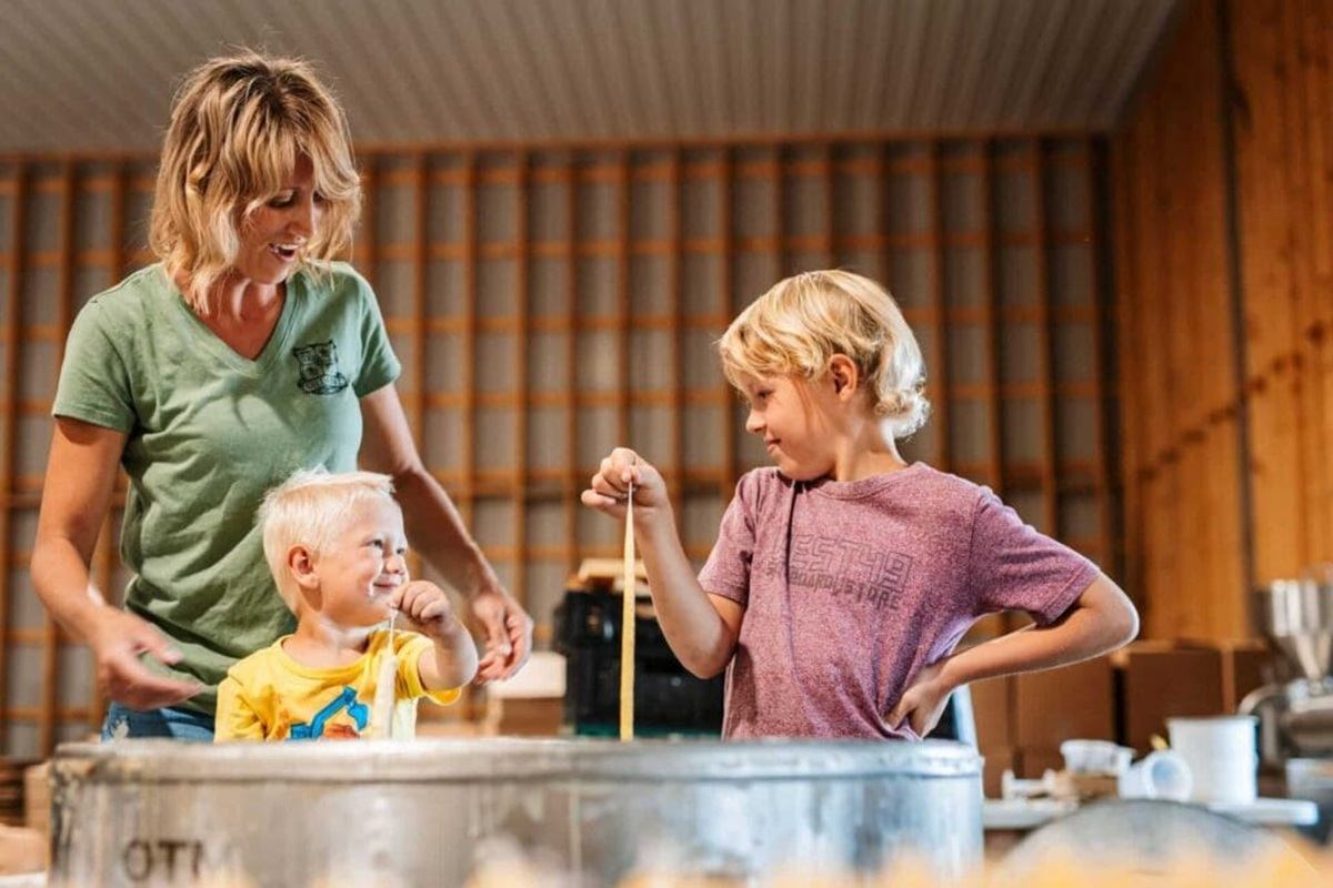 Gull Lake Honey Company welcomes visitors to stretch fresh honey during a hands-on farm experience.