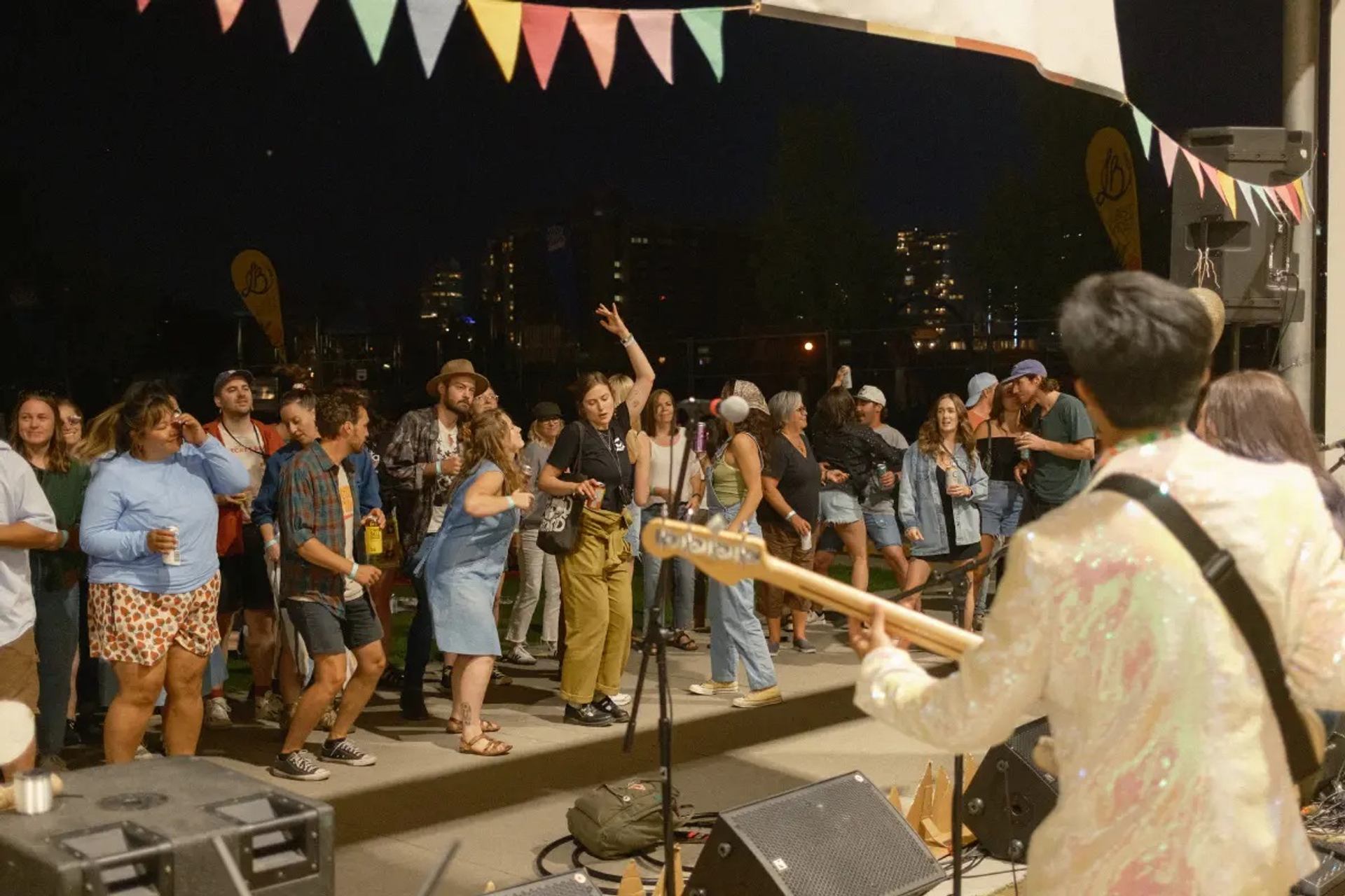 A performer at the festival with a group of people enjoying the music.