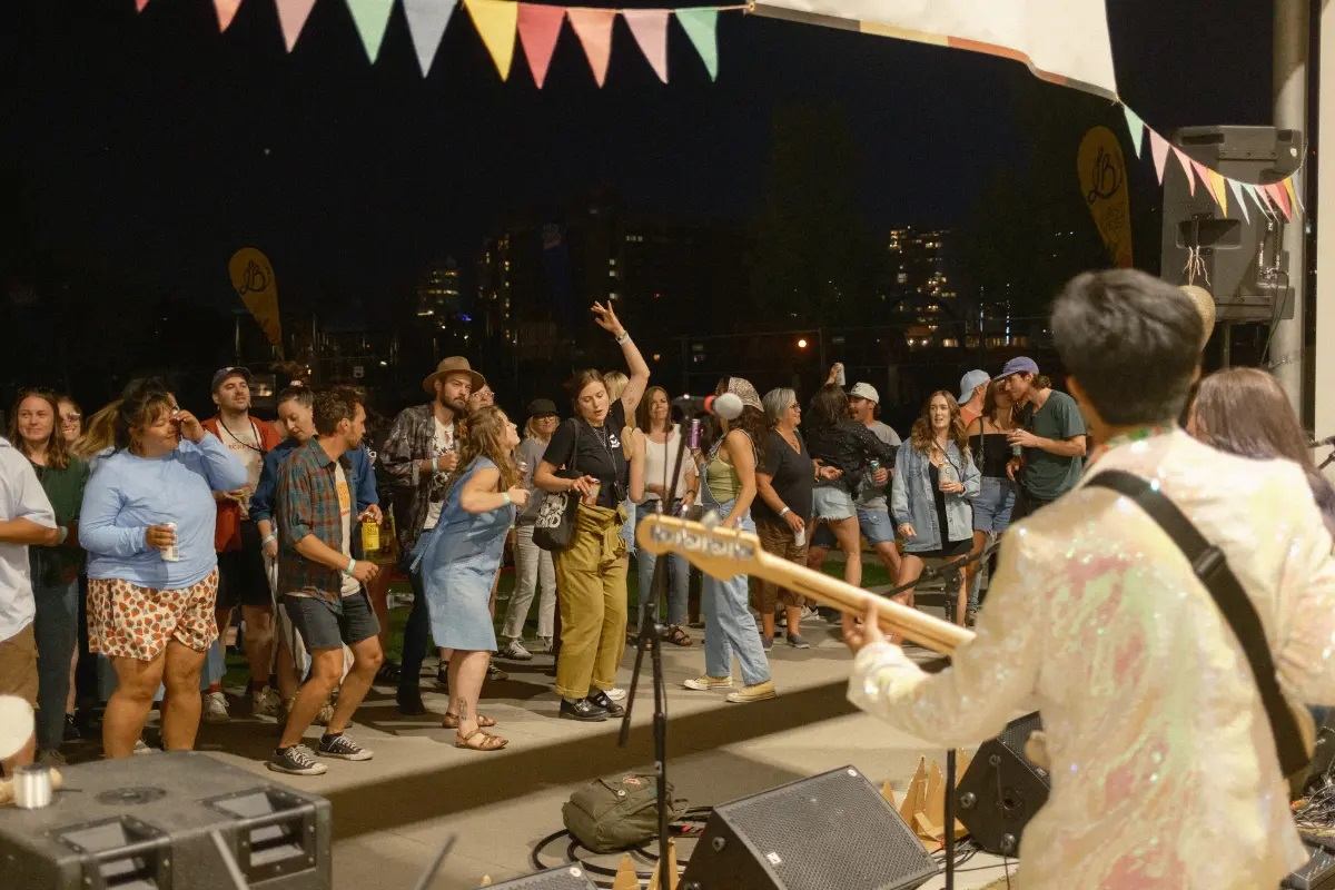 A performer at the festival with a group of people enjoying the music.