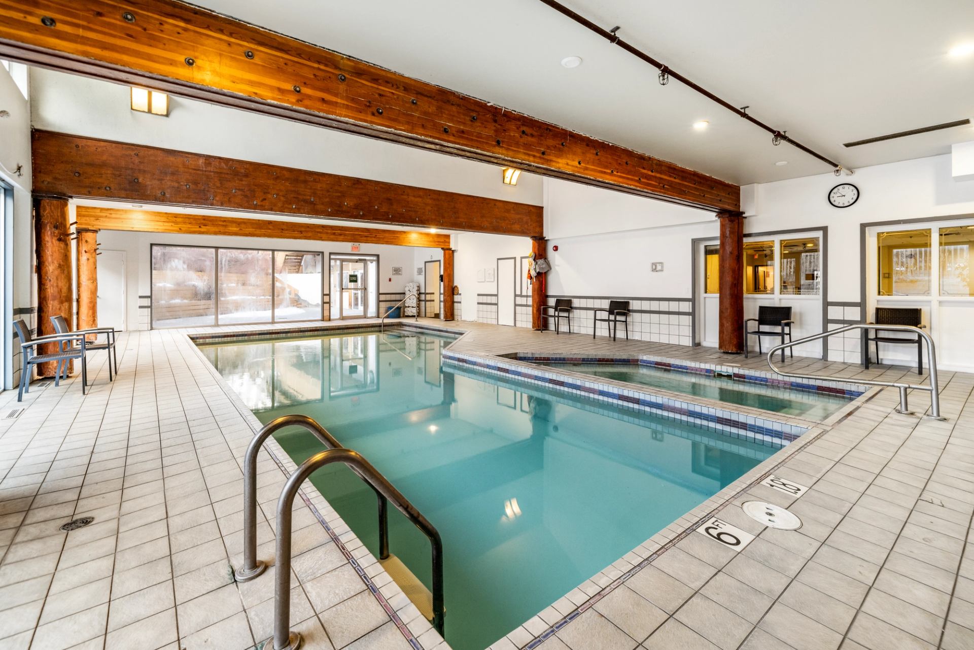 Large indoor pool with a hot tub on the side.