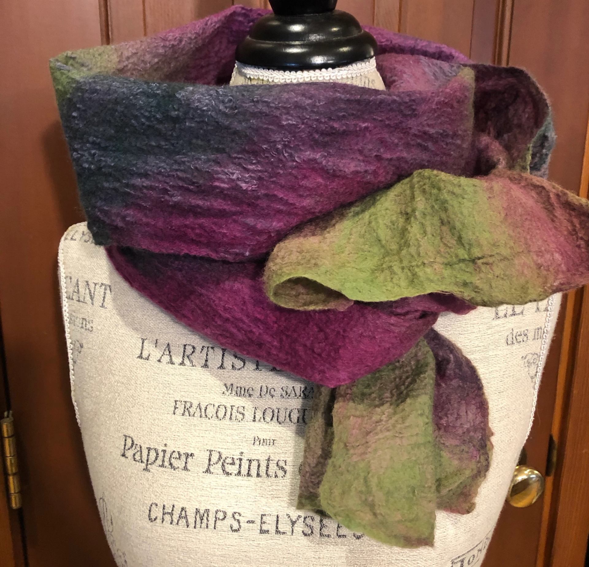 Mannequin with vibrant gradient scarf in soft, fuzzy texture.