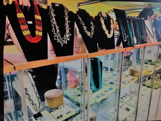 Jewellery display cases and hanging necklaces in a retail shop window.