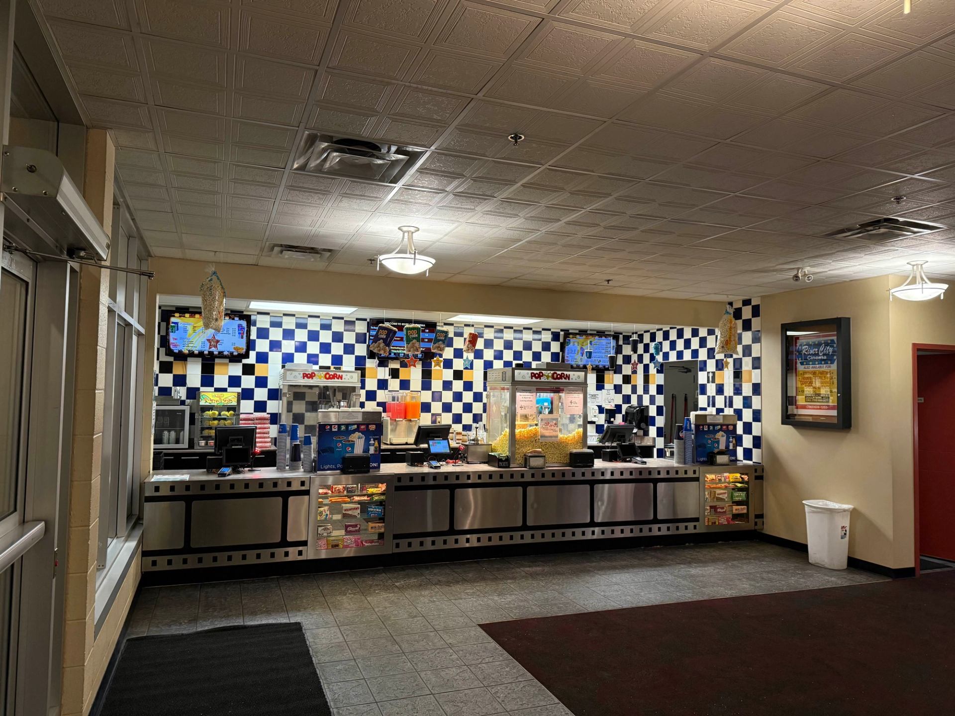 Concession stand with colorful snacks and drinks inside a cinema lobby.