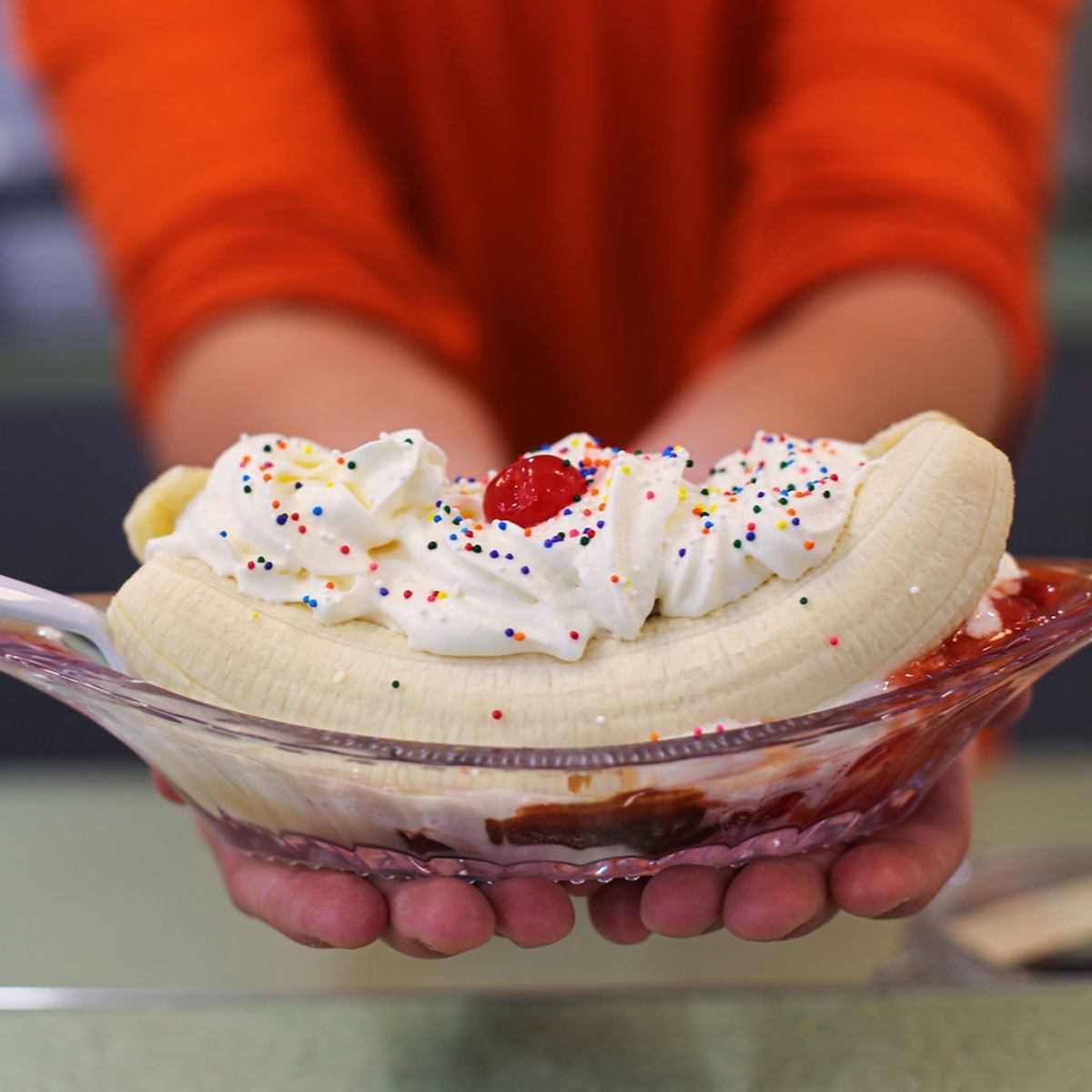 Banana split with whipped cream, sprinkles, and a cherry on top