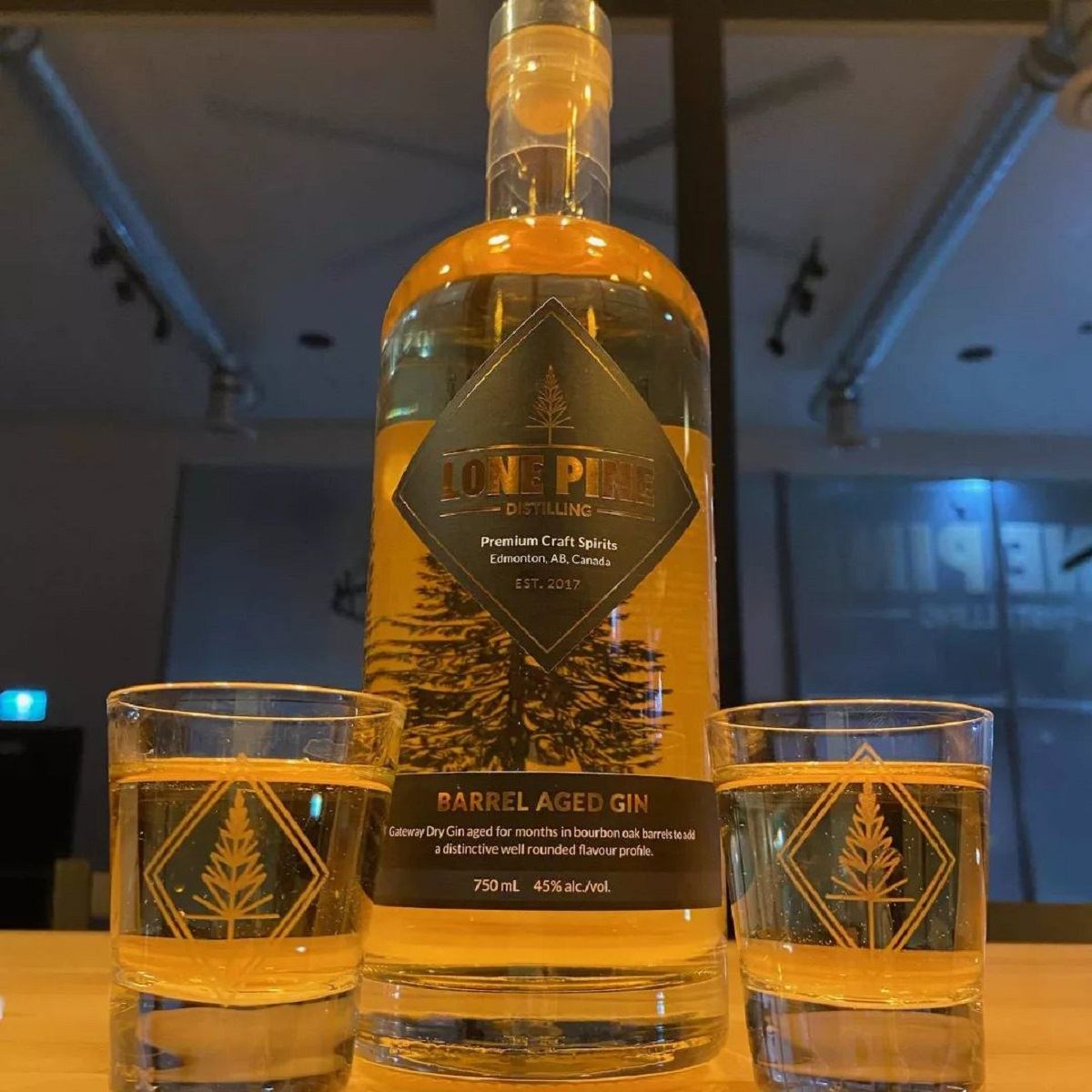 A bottle of Barrel Aged Gin and two glasses.
