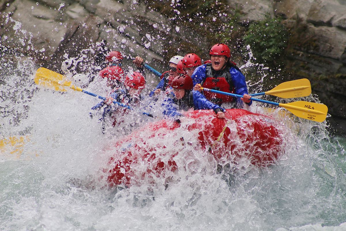 A group of people going down the river rafting.