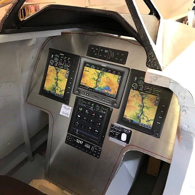 Aircraft cockpit with advanced avionics and navigation displays.