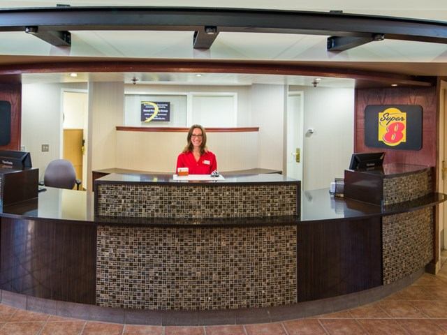 Reception desk at Super 8 Sherwood Park with staff and branded signage.