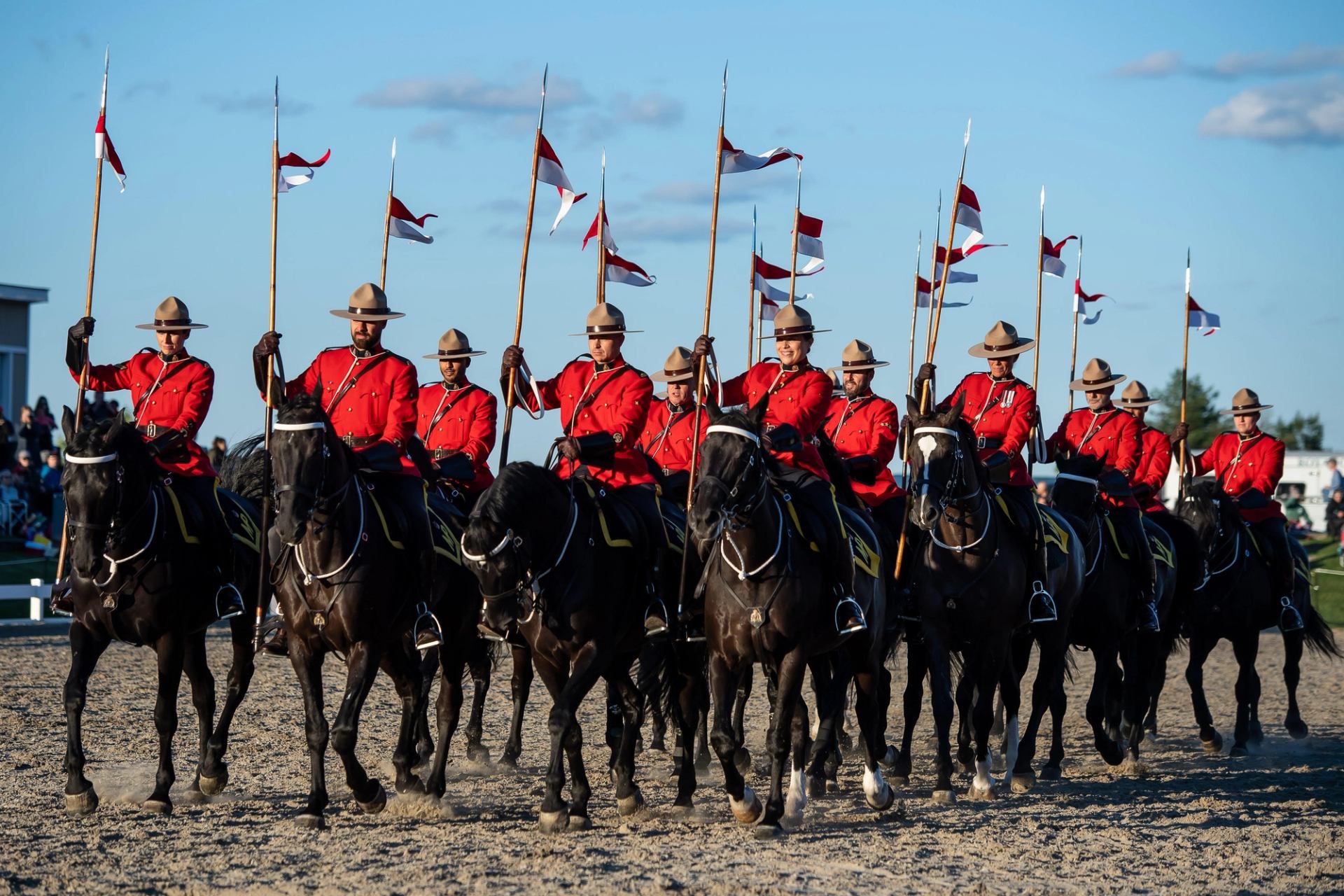 Mounted riders in red uniforms carry lances with red and white flags.