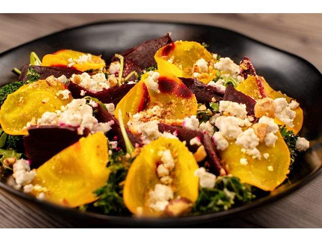 Salad with sliced golden and red beets, crumbled cheese and nuts on greens.