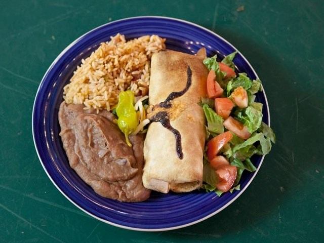 Plated meal with grilled steak, rice, and vegetables in a blue dish.