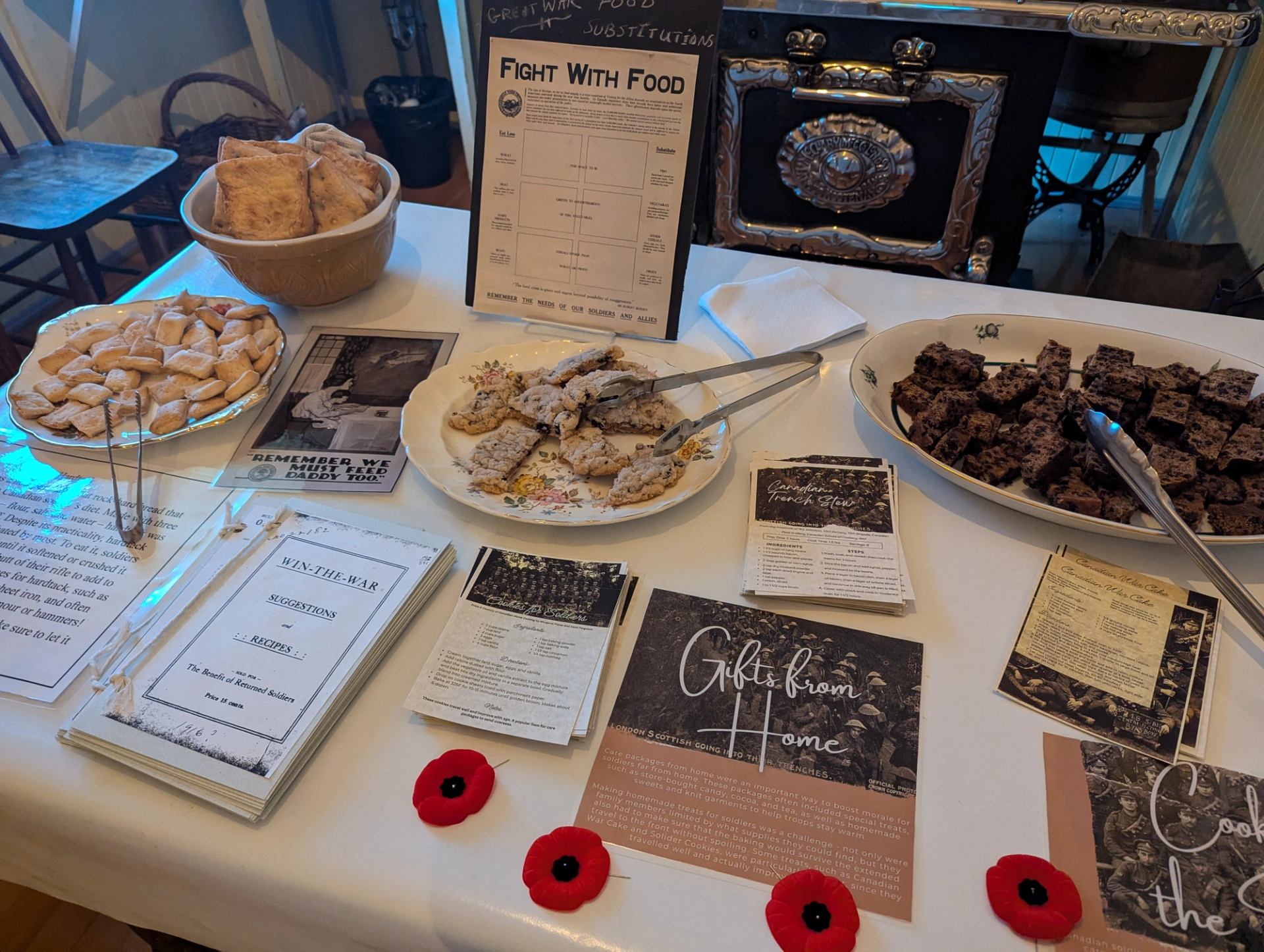 Display table with food samples, brochures, and a decorative metal plaque reading “Fight With Food.”