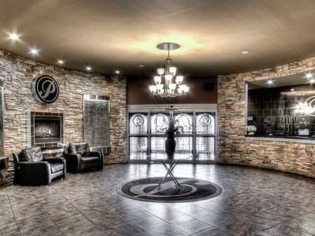 Elegant stone lobby with chandelier, fireplace, and Podollan “P” logo.