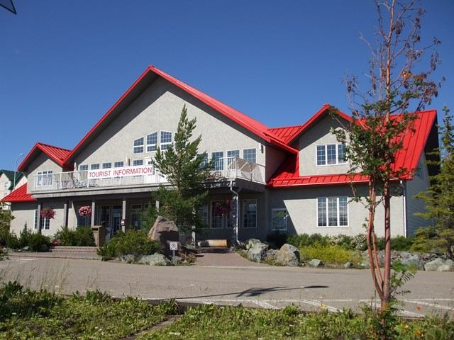 Grande Cache Tourism Centre with red roof, gables, and landscaped entrance.