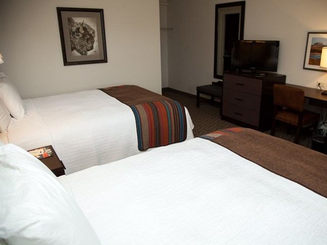 Badlands Motel room with two beds, desk, TV, and modern decor.